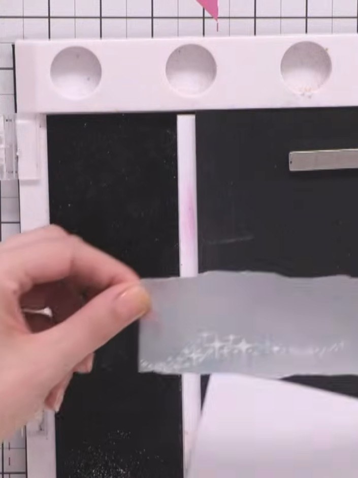 Step 5: Sprinkle white WOW embossing powder over the stamped stars on the vellum strip to cover the wet ink completely