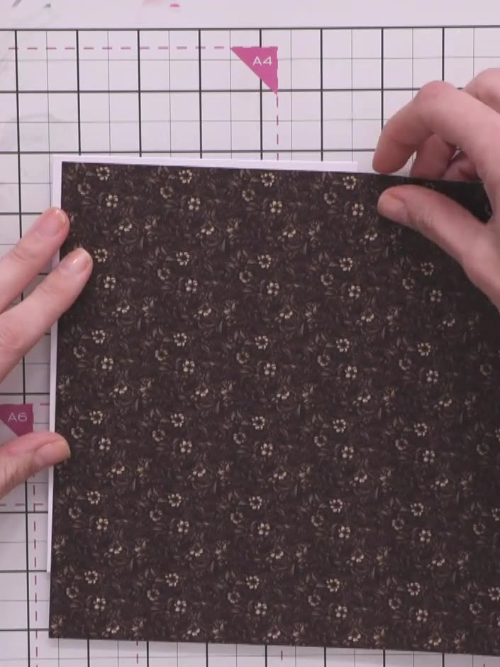 Step 1: Cut a piece of brown floral patterned paper from the Tailored Threads collection. Trim it to size to fit your 