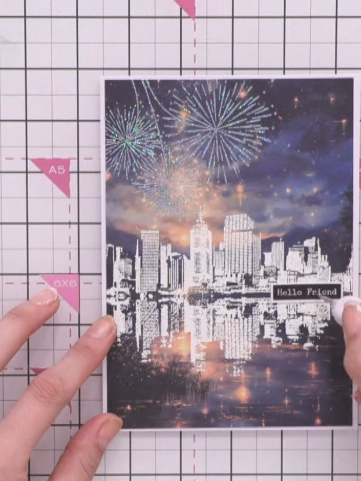 Step 9: Add a sentiment using washi tape to the card front. Position it to the side of the cityscape, ensuring it comp