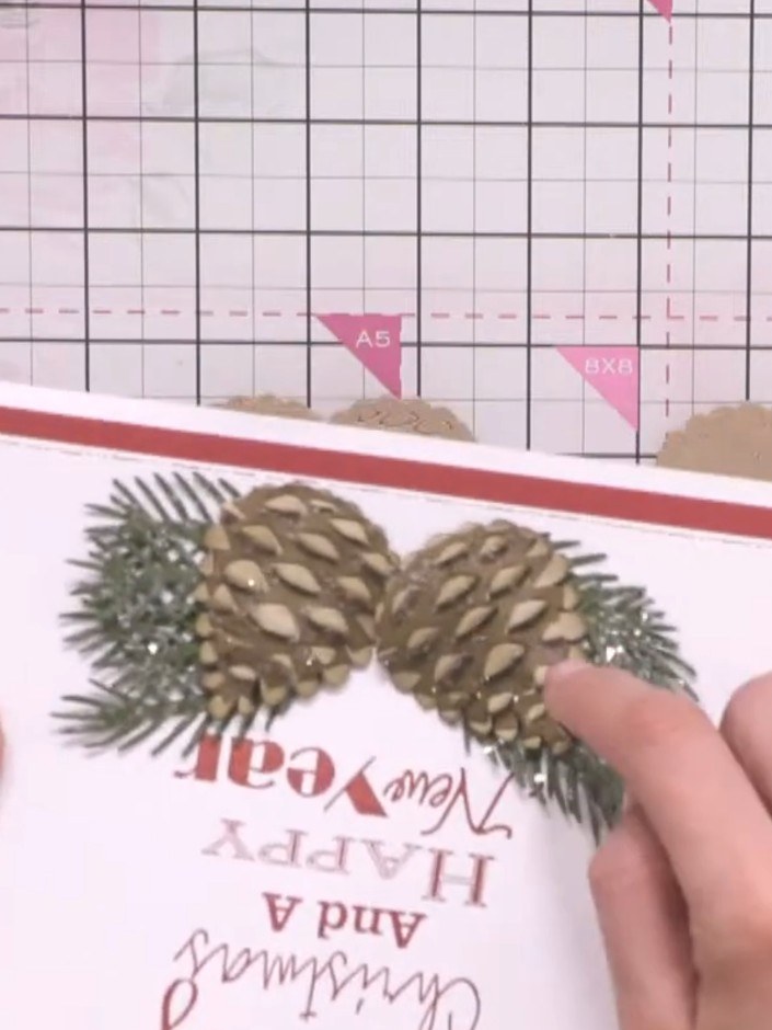 Step 10: Layer the pine cone die-cuts onto your card, positioning them as desired. Add white ink or sparkle to the edge