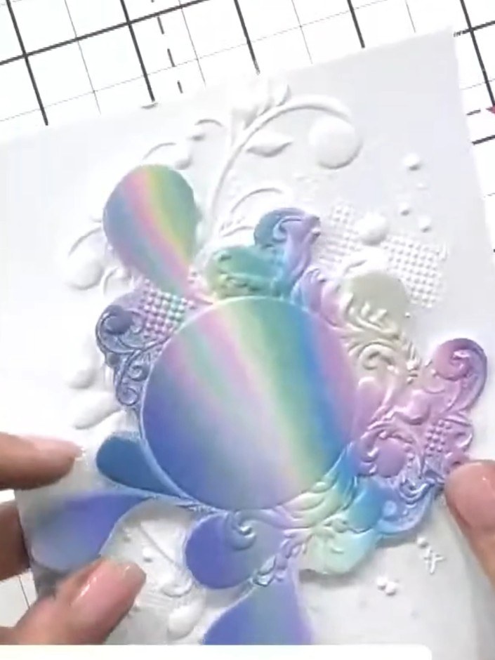 Step 8: Trim the embossed patterned paper and mount it onto white cardstock. The iridescent rainbow effect created by 