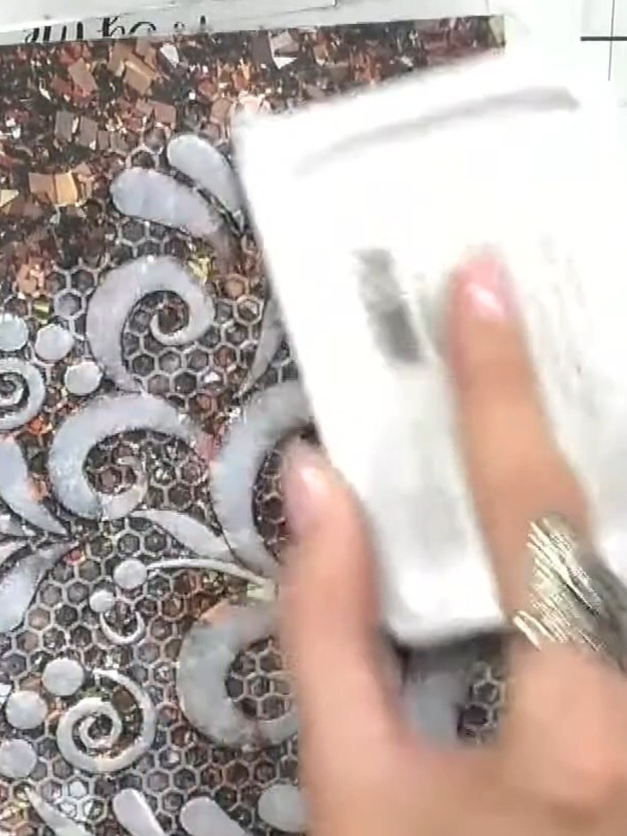 Step 3: Gently press the white ink pad onto the embossed design, focusing on the raised areas to highlight the pattern