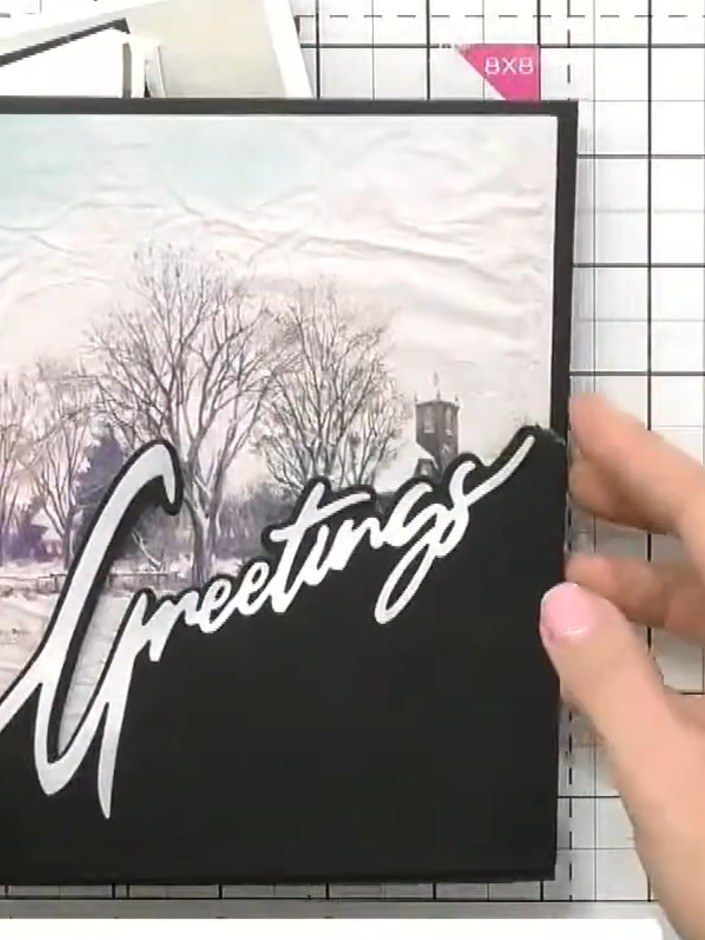 Step 1: Select a snow drift word die (such as 'Greetings') and position it diagonally across your card from one corner