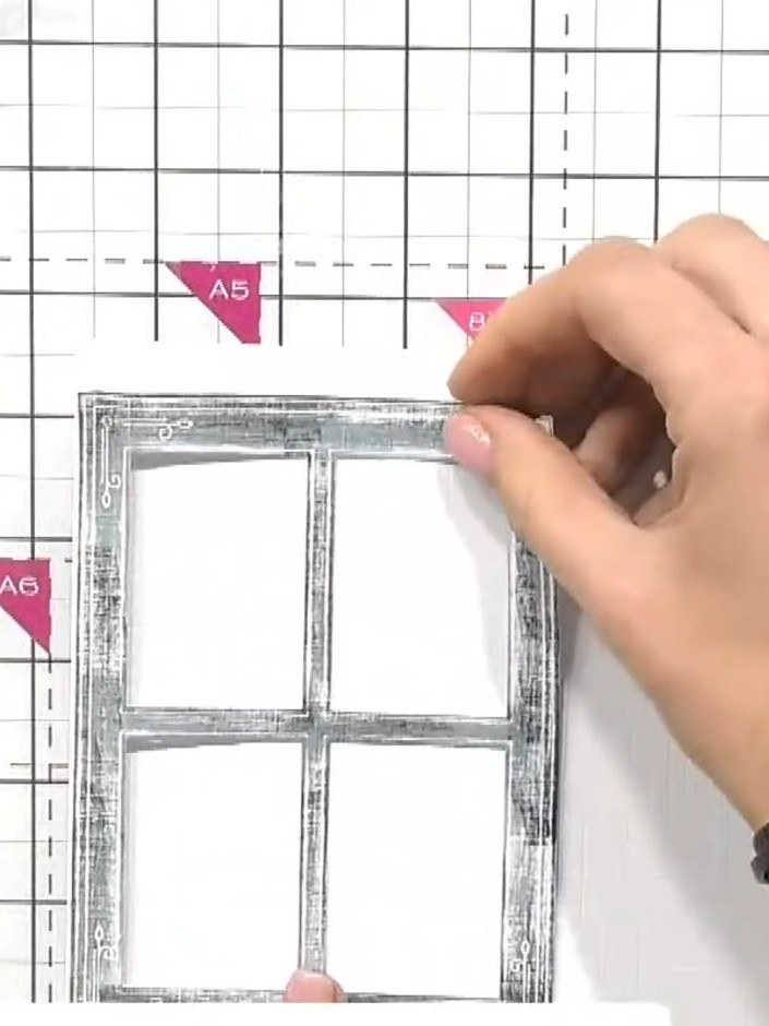 Step 2: Apply glue to the back of the die-cut window frame. Adhere it to your white card base, positioning it centrall