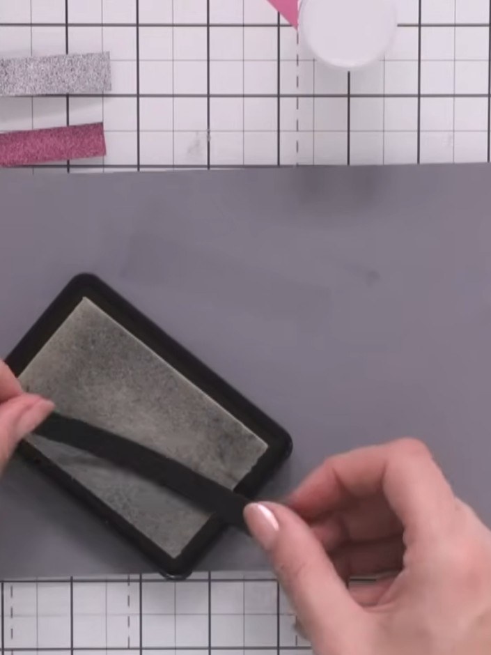 Step 5: Apply embossing ink to the final strip using the stamp pad. Sprinkle gold embossing powder over the inked stri