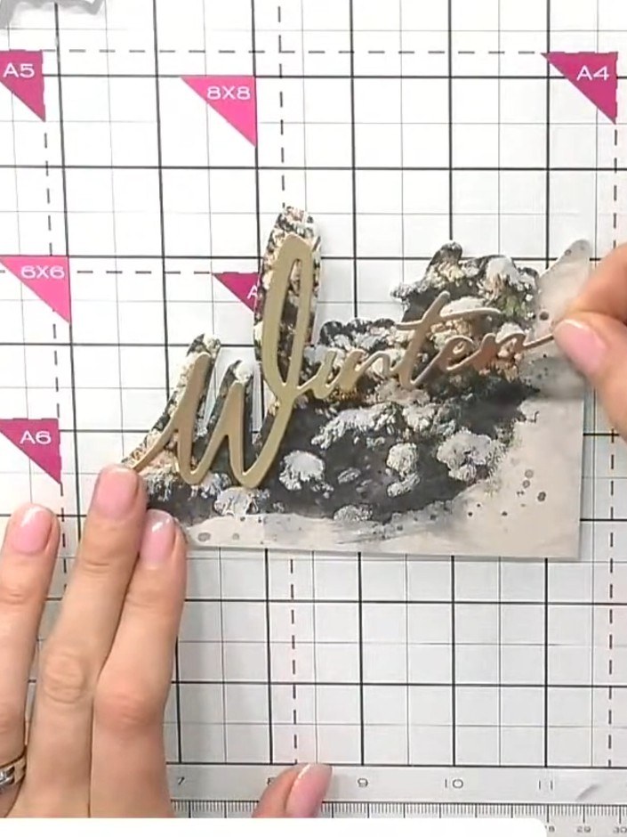 Step 5: Using grey watercolour or ink, colour the shadow detail on the chipboard window die cuts to add depth and dime