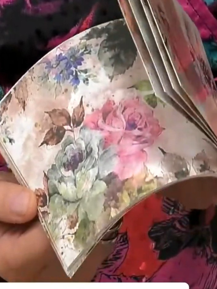 Step 7: Position your chosen painted floral mount on top of the embossed background card. Secure it in place using glu