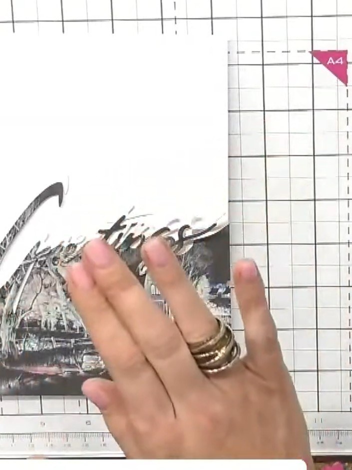 Step 9: Position the white die-cut word on top of the patterned paper layers, ensuring the pattern is visible both abo