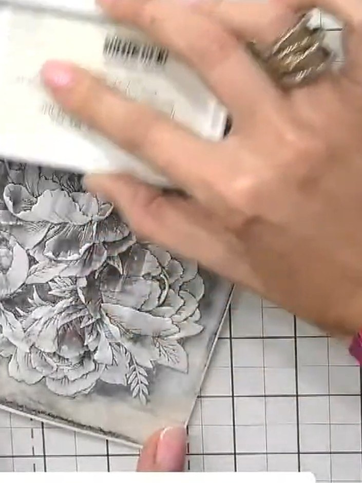 Step 5: Using a white ink pad, lightly brush over the embossed design to highlight the raised elements. Focus on the f