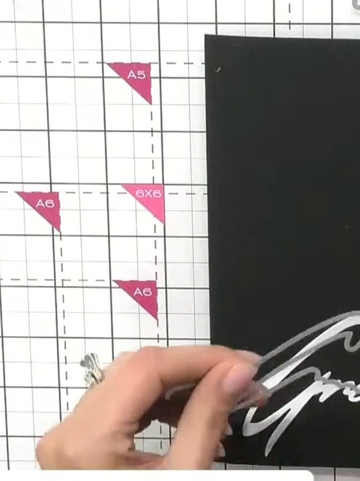 Step 3: Cut the 'Greetings' snow drift word die from black card. Position it at an angle on the card base, with the wo