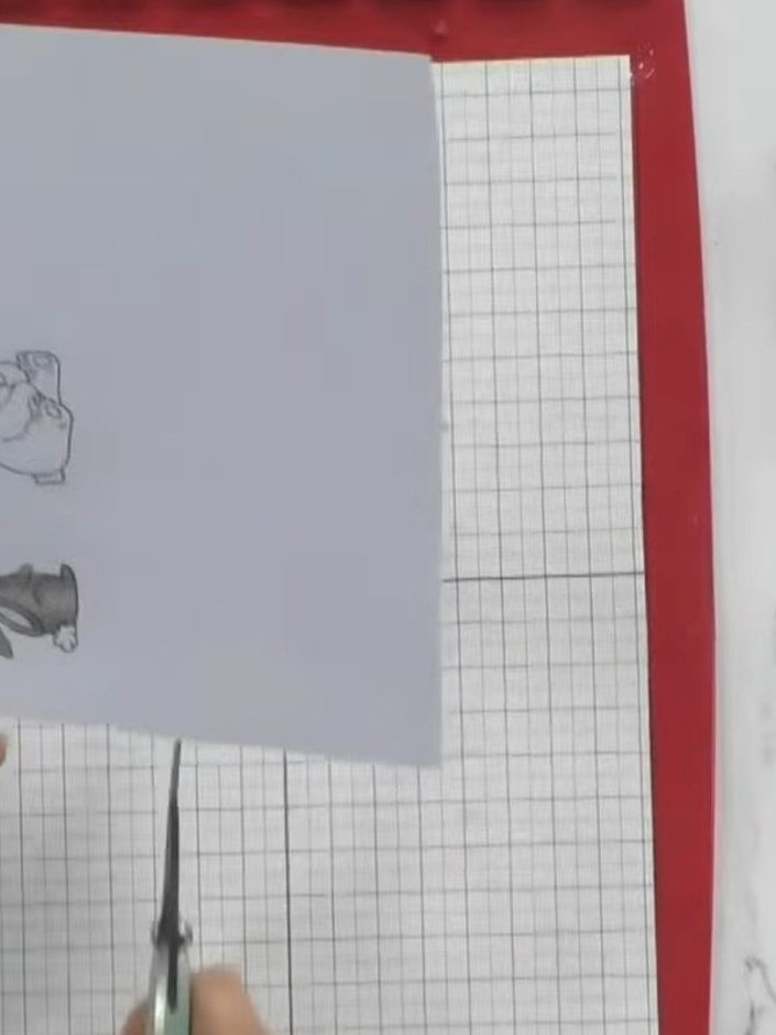 Step 3: Trim around the coloured animal stamp with scissors to remove the excess card, cutting carefully around the ou
