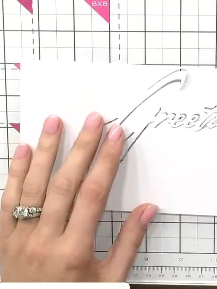 Step 1: Cut the snow drift word die (such as 'Greetings') from white card using your die-cutting machine.