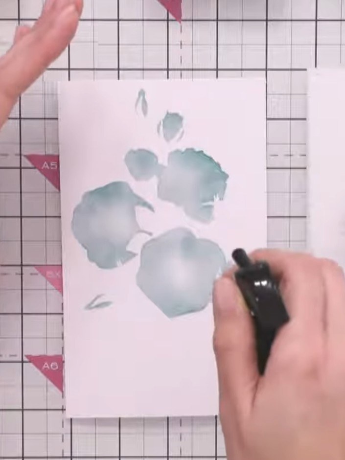 Step 8: Use the fourth stencil layer and apply black ink to the smallest details to add definition to the flower centr