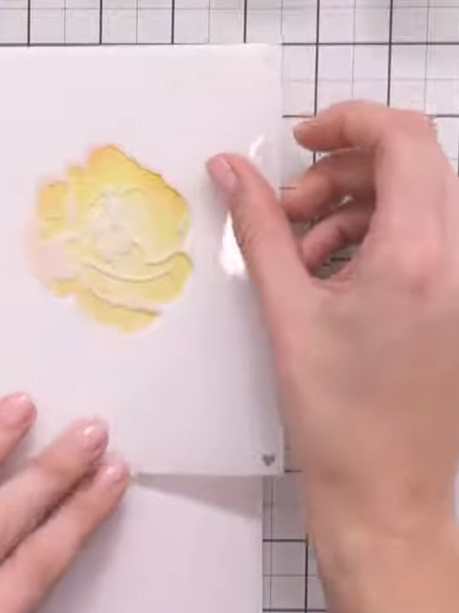 Step 5: Lightly spray water around the edges of the yellow stamped design to create a soft bleed effect. The water wil