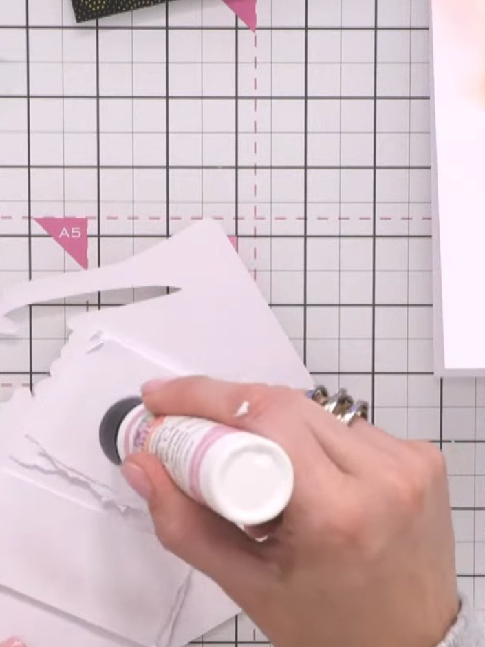 Step 7: Create foam tape pads by tearing small pieces of white card and stacking them together. Use these to raise the