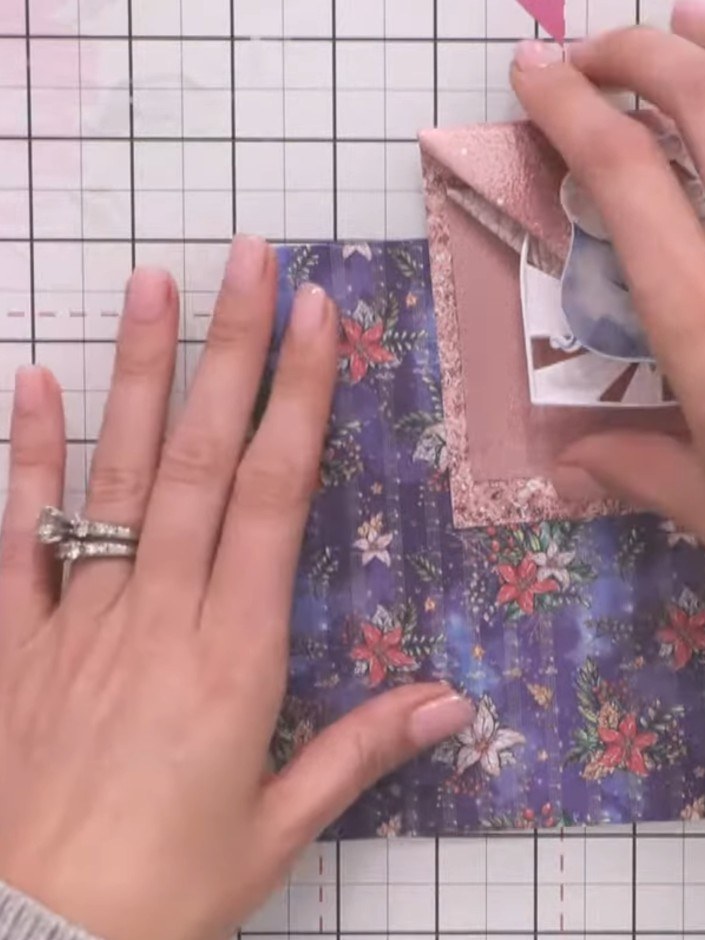 Step 5: Fold both side flaps back down towards the bottom of the floral patterned paper, creating neat diagonal folds 
