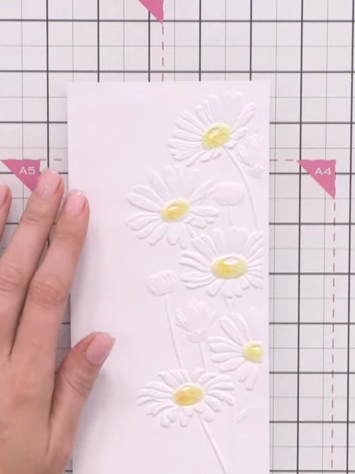 Step 5: Using a small blending brush, apply the pale coloured wash into the centre of the embossed daisy. Work gently 