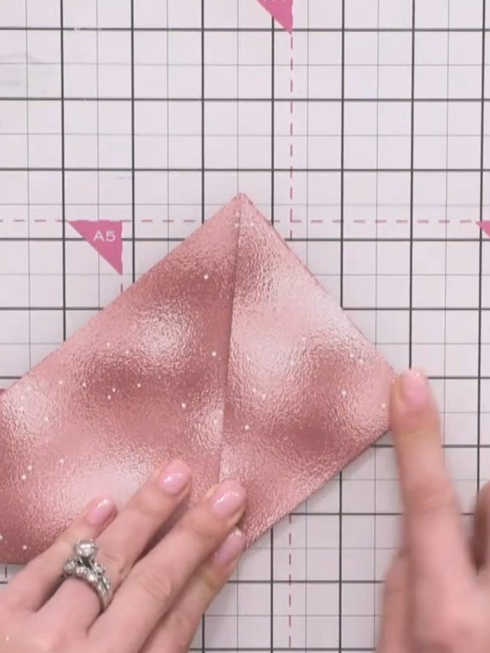 Step 3: Fold the bottom right corner up to align with the top point, creating a triangular shape. Line up the edges as