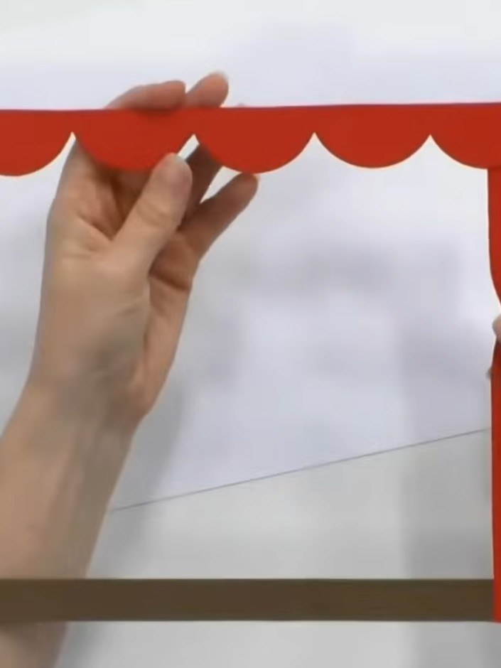 Step 1: Cut a red cardstock frame with a scalloped decorative edge along the top and sides. Remove the centre piece to