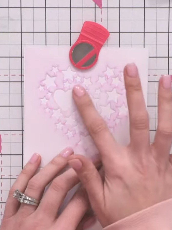 Step 6: Place the stencil back over the embossed heart detail on your card, aligning it carefully with the embossed pa