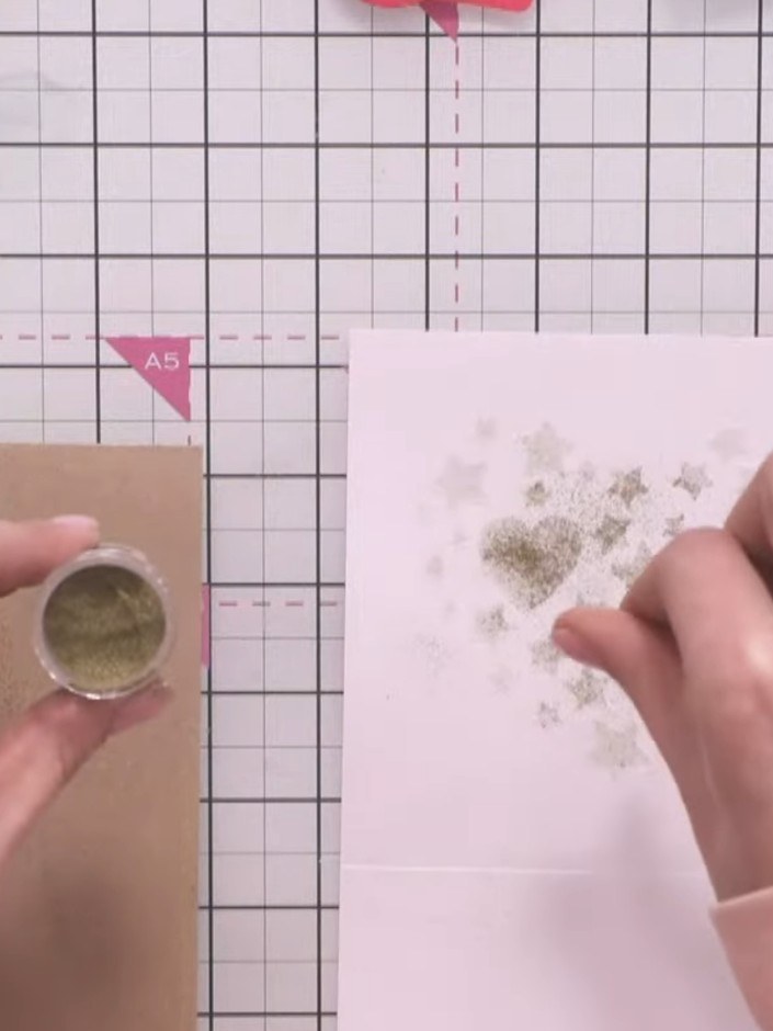 Step 8: Sprinkle gold embossing powder onto the sticky embossing ink on your card. Shake off the excess powder onto a 