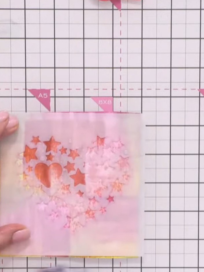 Step 5: Spray water directly onto the stencil whilst it's still in place on the card to help lift and blend the ink fr