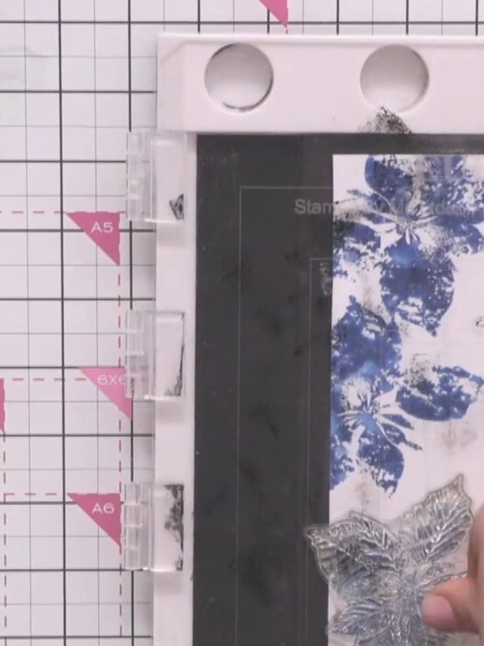 Step 10: Sprinkle white embossing powder over the stamped poinsettia image on the card panel. Ensure the powder covers 
