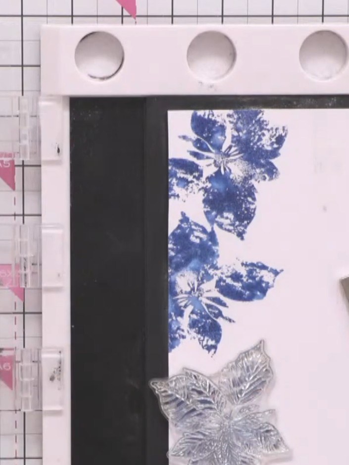 Step 9: Stamp the white outline detail over the teal watercoloured poinsettia design, offsetting the stamp slightly fr