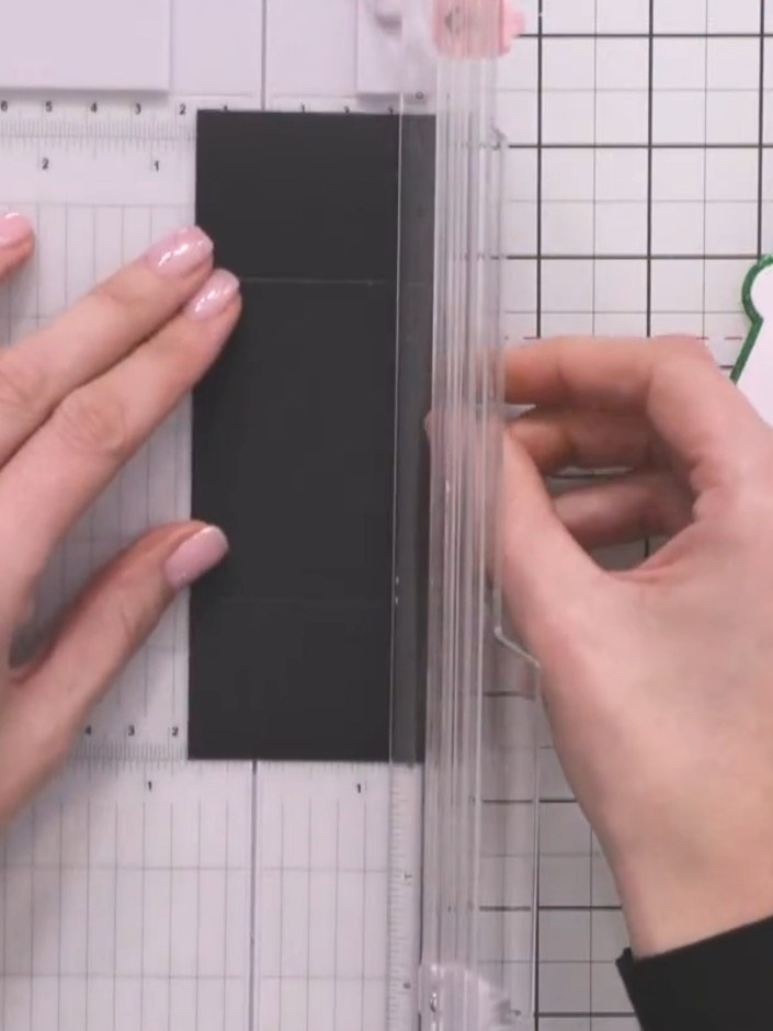 Step 5: Using your scoreboard, score half an inch (approximately 1.3 cm) down each long side of the black card whilst 