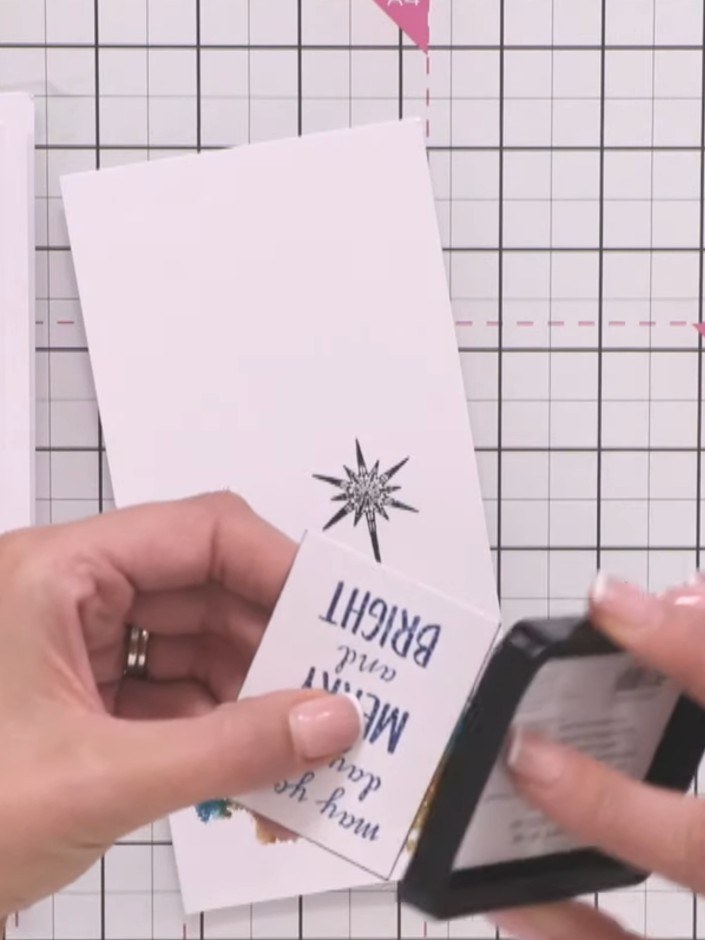 Step 7: Once the cabin is dry, ink the cabin stamp in black and stamp it directly on top of the watercoloured image to