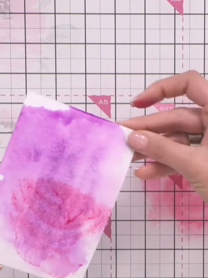 Step 4: Add pink ink to different areas of the card, allowing the colours to blend naturally where they meet the purpl