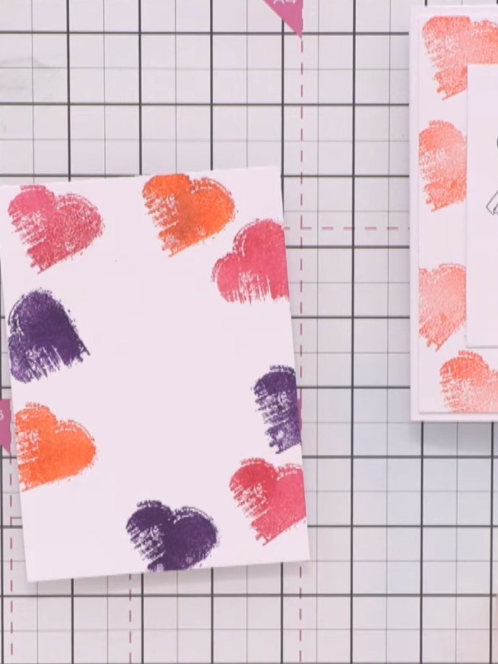 Step 4: Clean the heart stamp and ink it with orange ink. Stamp three more hearts onto the card front, positioning som