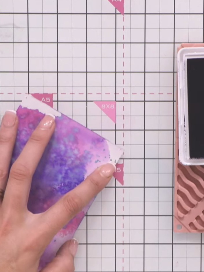 Step 2: Using a blending brush and dark purple or indigo ink, edge the watercoloured background panel to create a dark