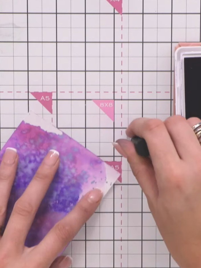 Step 3: Stamp the reflection collection stamp in black ink onto the watercoloured background, positioning it in the lo