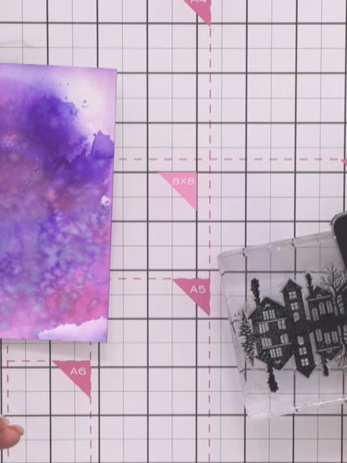 Step 7: Stamp the witch on a broom silhouette from the Stamps By Me set in black ink onto the purple watercolour backg