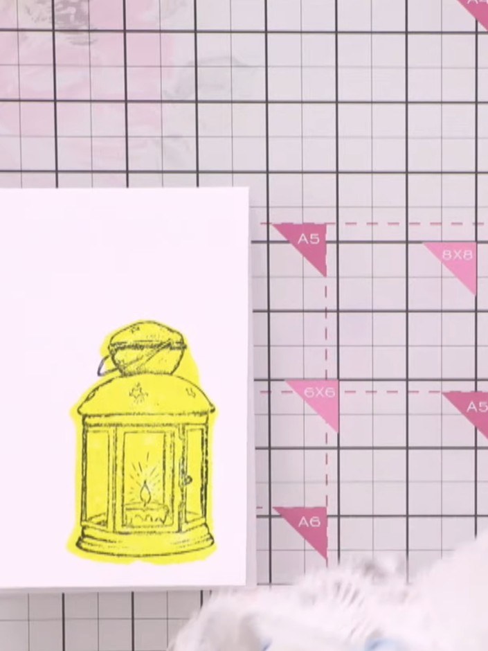 Step 9: Add spatter texture around the yellow lantern design using orange ink. Apply the ink spatters to create a deco