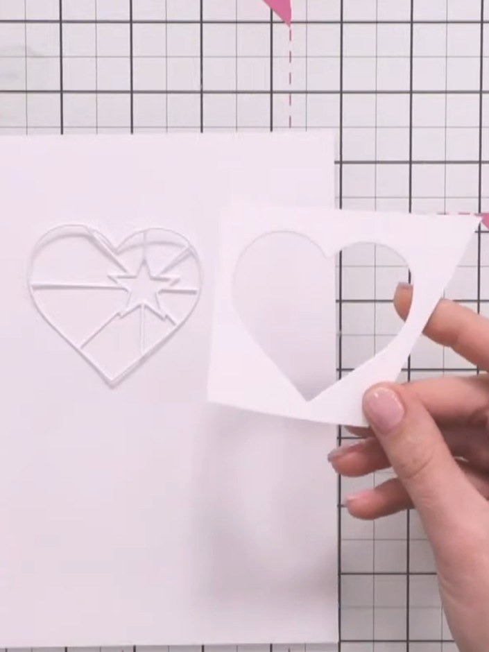 Step 3: Leg eines der größeren ausgestanzten Herzen mittig auf ein Stück weißen Cardstock – es dient dir als Schablone.