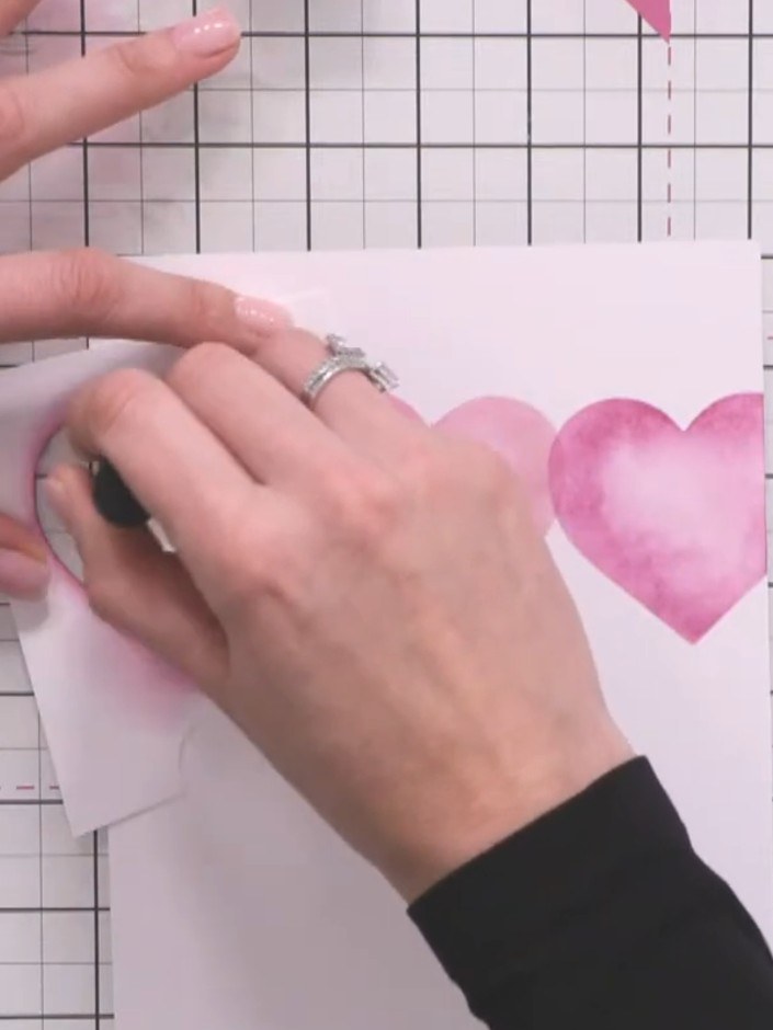 Step 6: Move the stencil to reveal a third heart position and blend teal ink through the stencil to create the third h
