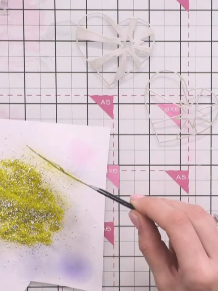 Step 8: Sprinkle yellow embossing powder over the first inked heart. Heat-set the embossing powder using a heat tool u