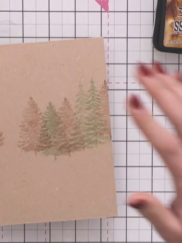 Step 4: Using a green ink pad, stamp additional trees amongst the brown ones to create colour variation and add depth 