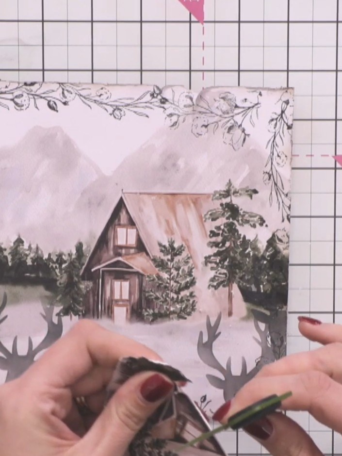 Step 8: Adhere the completed framed winter cabin scene to your card base, positioning it slightly off-centre for added