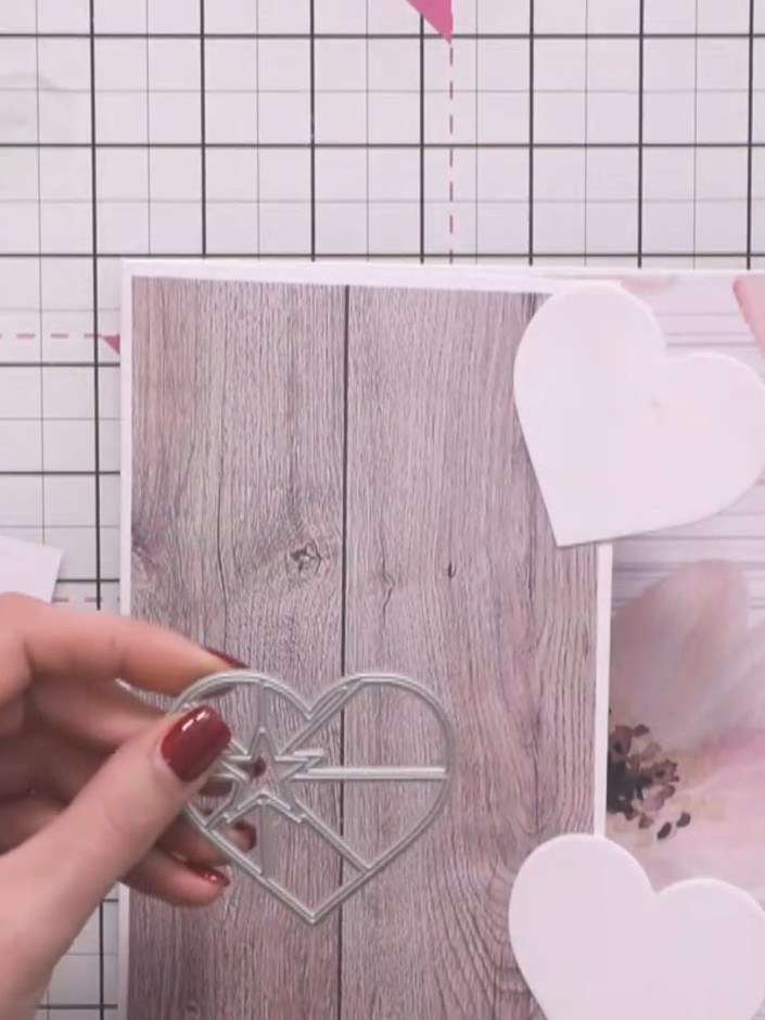 Step 8: Position a decorative heart outline die-cut over one of the white heart shapes on your card front. The heart o