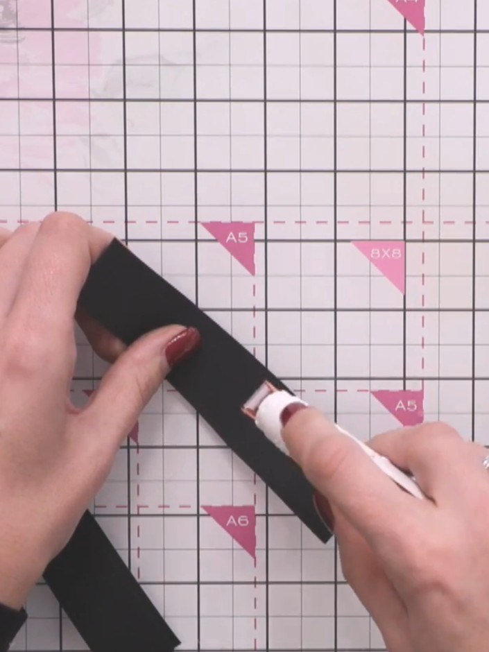 Step 10: Create a backing pad by layering scraps of black card stock together. Apply tape to secure the layers and buil