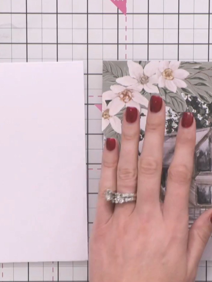 Step 3: Adhere the fussy-cut floral patterned paper onto your white card base using adhesive, positioning it in the to