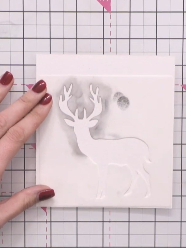 Step 1: Position the stag stencil at the bottom of your watercolour card. Tap excess ink off your sponge, then apply t