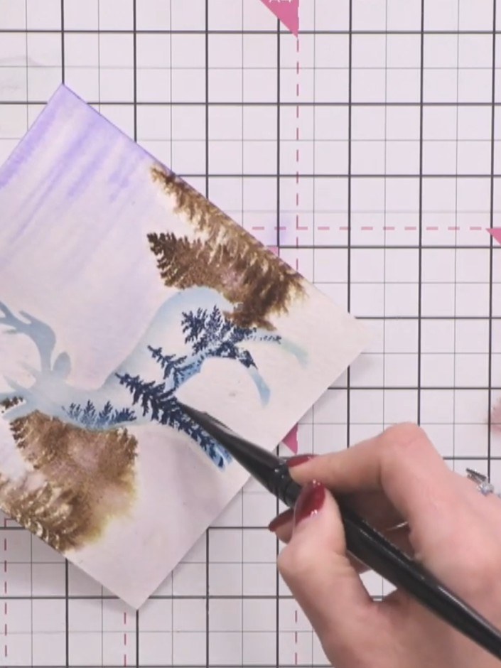 Step 10: Using a water brush, wet the bottom portion of the card to prevent harsh white edges at the base. Apply sparkl