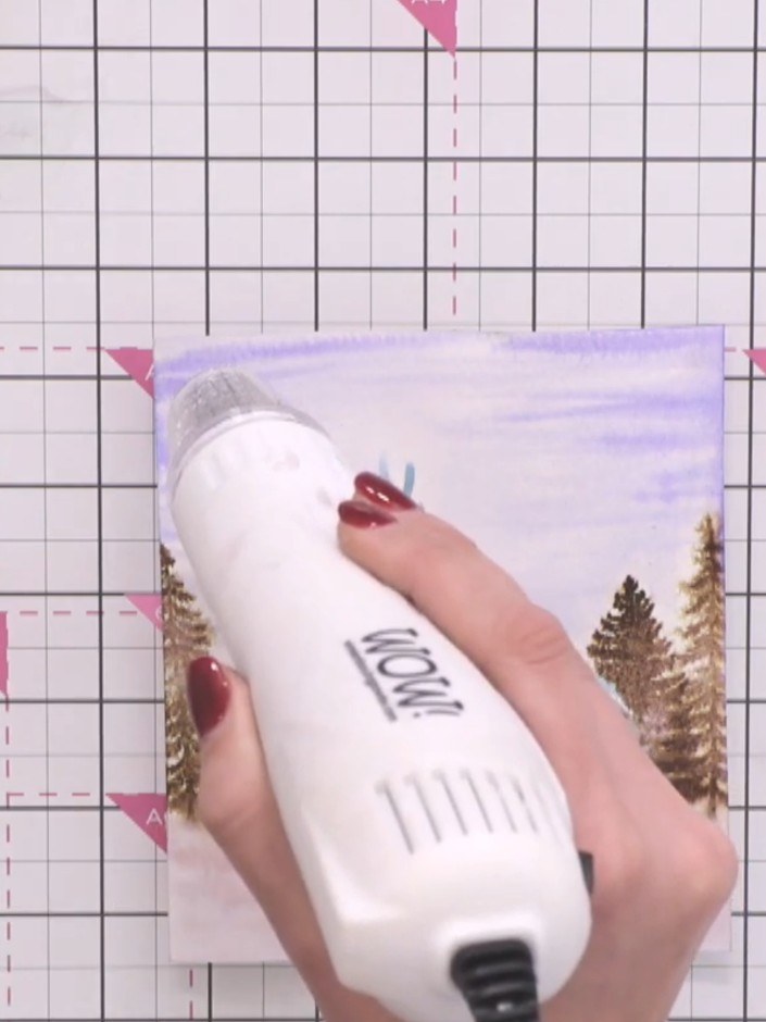 Step 11: Use a heat tool to thoroughly dry the watercoloured card, ensuring all the painted elements are completely set