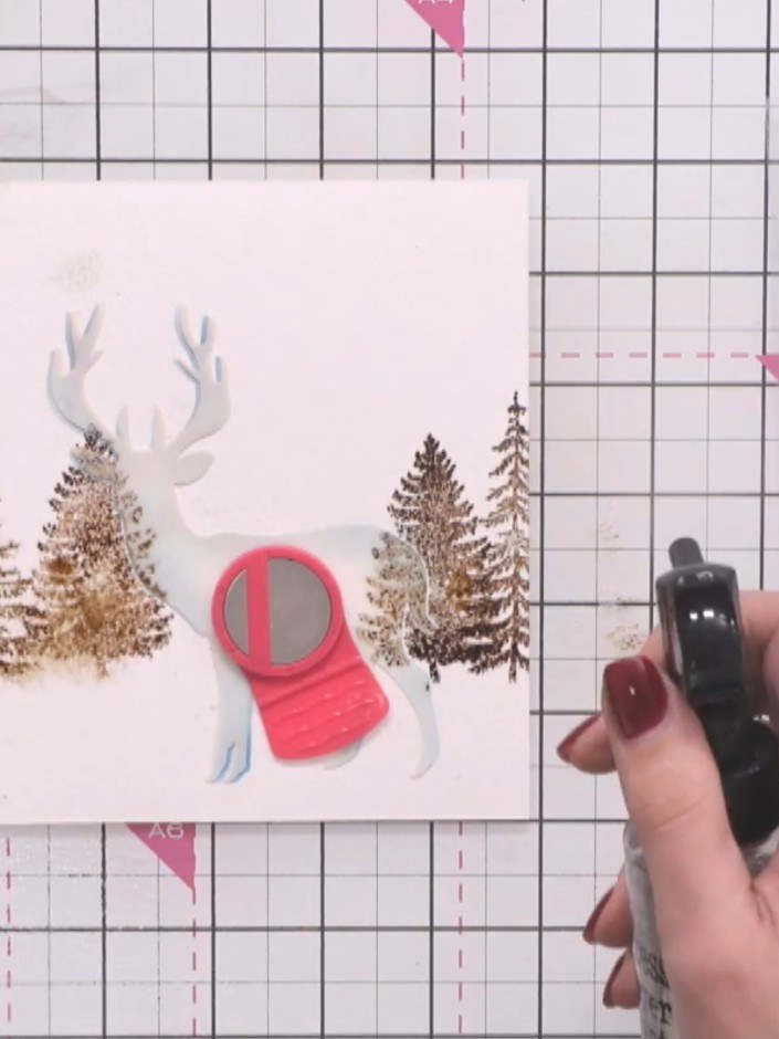 Step 5: Hold the stencil in place and lightly mist the area around the stag with water using a spray bottle to create 