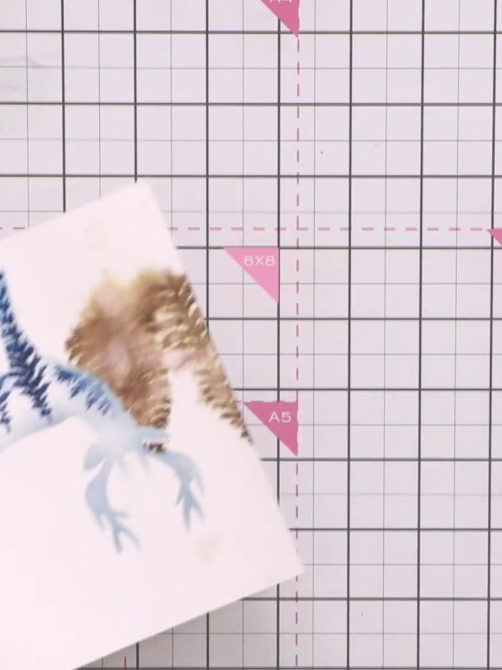 Step 8: Using a flat brush, apply diluted blue ink to the top portion of the card with water, creating a loose wash ef