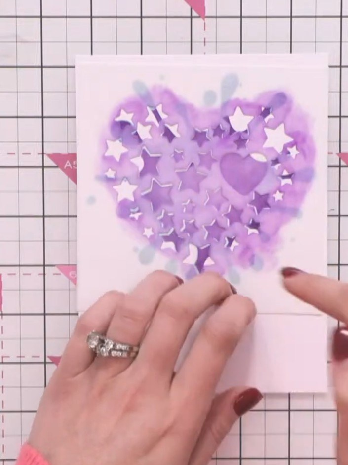 Step 6: Remove the heart stencil from the centre. Reposition just the splat stencil over the card and fill in the rema
